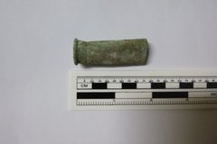 Brass casing next a rule to show size