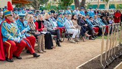 Audience seated outside watching a groundbreaking ceremony