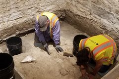 Two archaeologists inside excavation unit