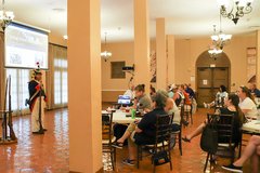 A historian in soldier period attire speaking to a seated audience