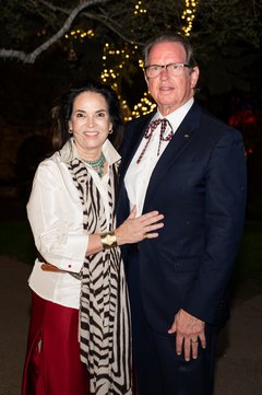 Woman wearing a print scarf and a man wearing a bolo tie at an event