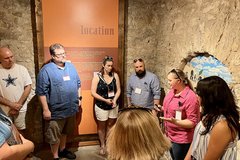 A group of men and women standing in a circle in the Alamo Long Barrack