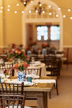 Tables set up with place settings and colorful flowers in Alamo Hall