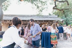Guests enjoying bites and cocktails in Alamo Hall Patio