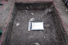 Interior square of an excavation unit with a white board and marker in the center