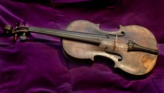 Violin laying on a purple backgdrop