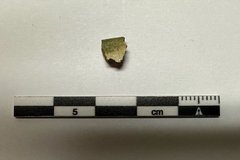 One stone fragment next to a black and white ruler