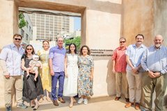 Family members standing at opening to a gate next to signage with letters