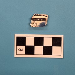 Small piece of ceramic with black coloring a swirl pattern