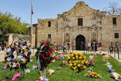 Floral wreaths on the grass in front of Alamo Church