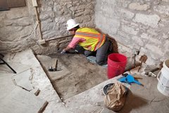 Excavation test unit with archaeologist