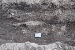 Dirt archaeology area with a pink line and a square whiteboard