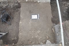 Whiteboard and black step ladder inside of an excavation unit