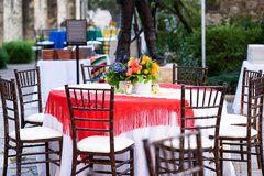 Table with white linens, red accents and colorful flowers