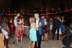 Couples dancing outdoors with string lights in the background