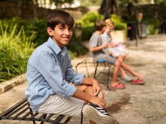Visitors take a seat in the shady Alamo garden.