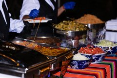 Caterer serving enchiladas at the buffet table