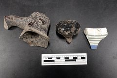 Ceramic sherds and a doorknob next to a ruler for size