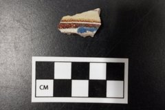 Ceramic sherd fragment next to a ruler for size