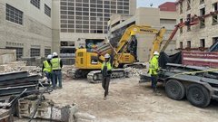 Yellow construction truck and workers on a dirt area