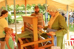 Living Historian demonstrating a textile loom to visitors