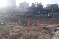 View of construction area in front of Alamo Street businesses with construction trucks