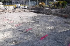 Large dirt area to the left of the Alamo with pink lines for marking
