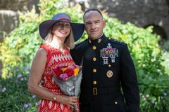 Marine General and his wife holding a bouquet of flowers after his ceremony