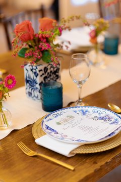 Close up of place setting with blue patterned china and colorful flowers