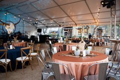 Round tables set up for an event inside a tented structure