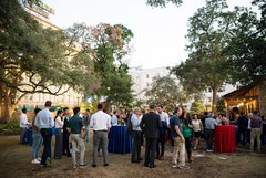 Large group of guests mingling at an event in Alamo Gardens