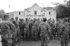A group of soldiers surrounding two soldiers speaking