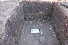 Inside of excavation unit with a whiteboard and marker at the bottom