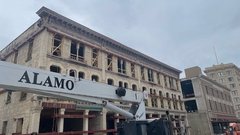 Crane with the word "Alamo" in front of the Crockett Building