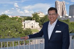 Man at La Vista Terrace with the Alamo in the background