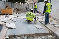Construction workers laying out flagstone
