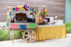 Beverage table with a yellow linen next to a cart with appetizers