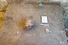 Square deposit inside an excavation unit with whiteboard and ruler