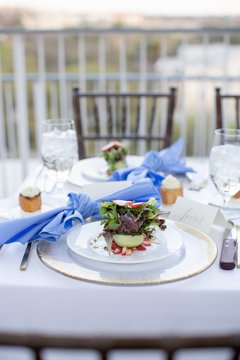 Salad presented on a white plate next to a blue napkin