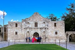 A group of people in front of the doors to Alamo Church