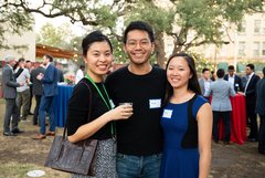 Three guests smiling at an event in Alamo Gardens