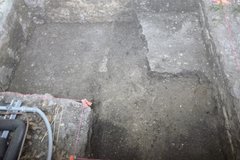 Inside an excavation unit with a square limestone piece in the right top corner