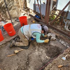 Archaeologist digging in an excavation unit