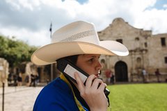 Child in cowboy hat listening to an audio wand.