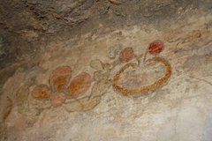 A red, yellow and pale green painted floral design on the Alamo’s walls.