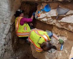 Two archaeologists inside an excavation unit