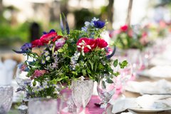 Pink and purple wildflower arrangement on a set table
