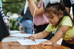 A young visitor with a quill pen at the Alamo.