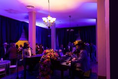 Dueling pianos in Alamo Hall with purple uplighting, large florals between the two pianos
