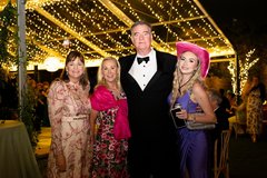 Wedding guests in black tie attire under string lighting of dance floor at night